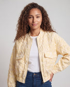 Women's lightweight bomber jacket with quilted texture, oversized pockets, and elastic hem