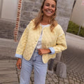 Women's short-cut quilted transitional jacket with round neck, decorative piping, and turn-up cuffs Fashion Glam
