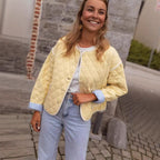 Women's short-cut quilted transitional jacket with round neck, decorative piping, and turn-up cuffs Fashion Glam