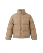 Women's short boxy travel puffer jacket with high collar, reinforced thermal lining, and elastic cuffs
